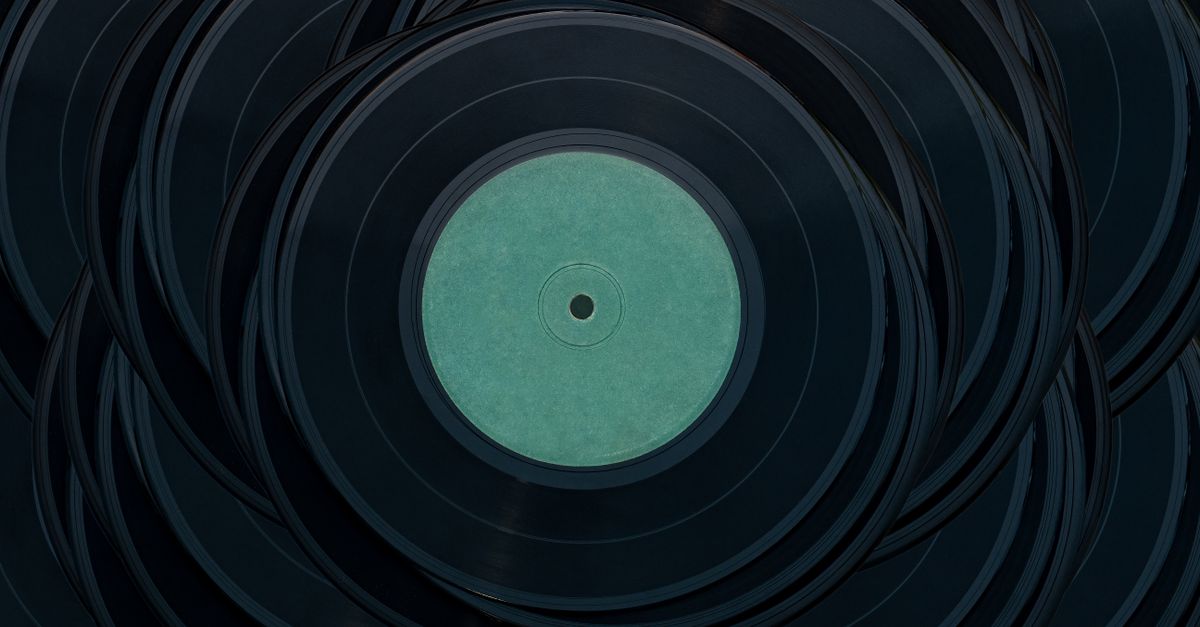 A top view of stacked vintage vinyl records creating an artistic pattern with a moody tone.