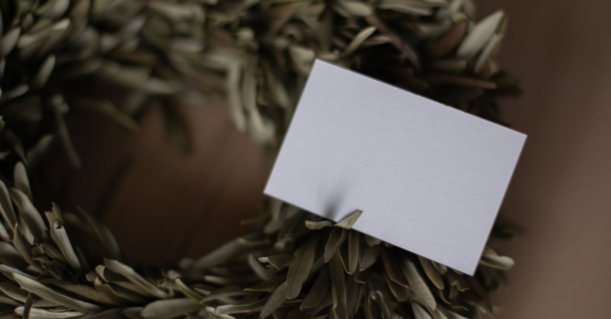 Close-up of rustic wreath with blank card for customization, ideal for seasonal greetings.