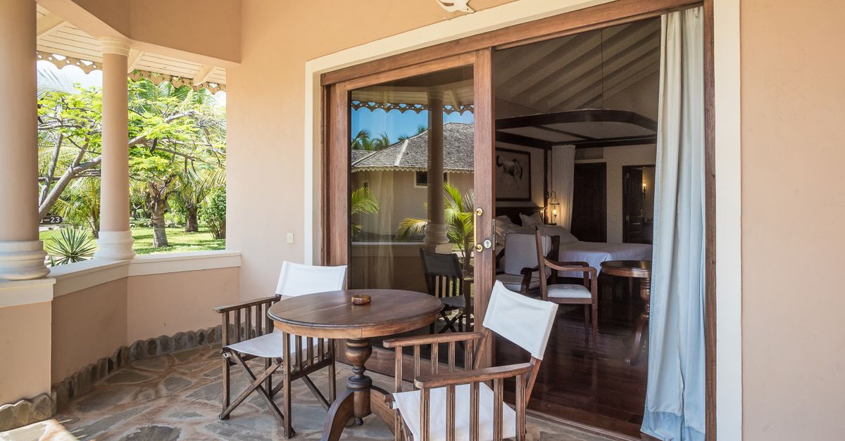 Charming villa patio in Malindi, Kenya, featuring wooden chairs and a table.