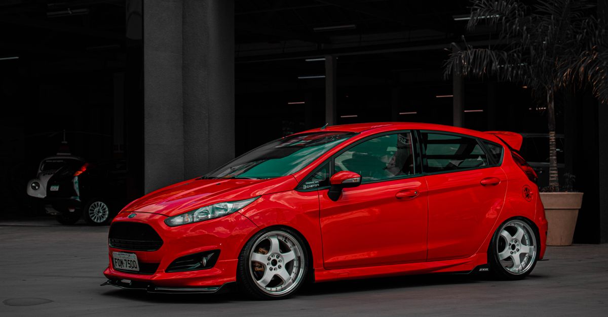 A stylish red Ford Fiesta parked in an urban setting, showcasing modern automotive design.