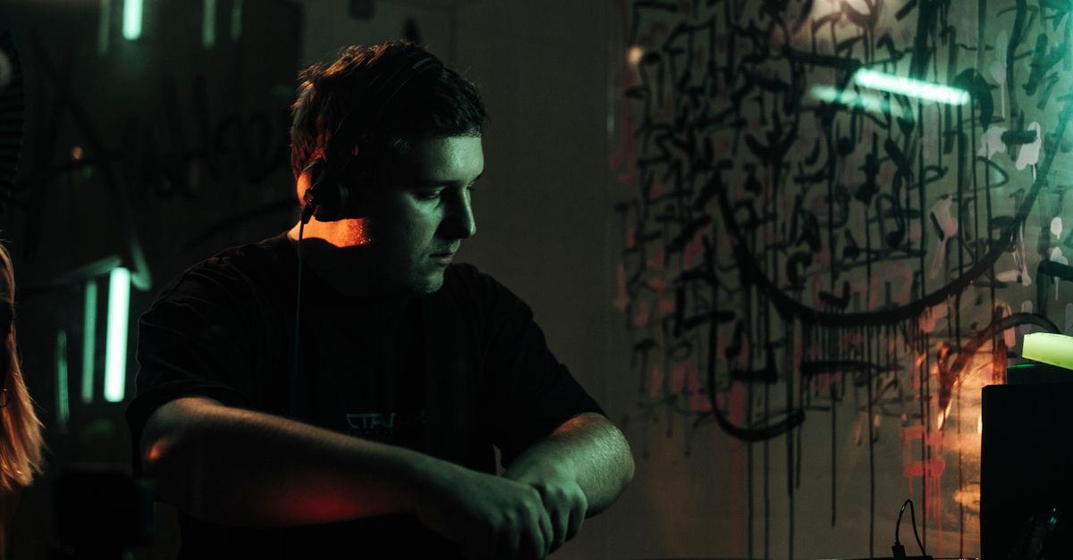 DJ performing at a vibrant nightclub with colorful graffiti art in Lwiw, Ukraine.