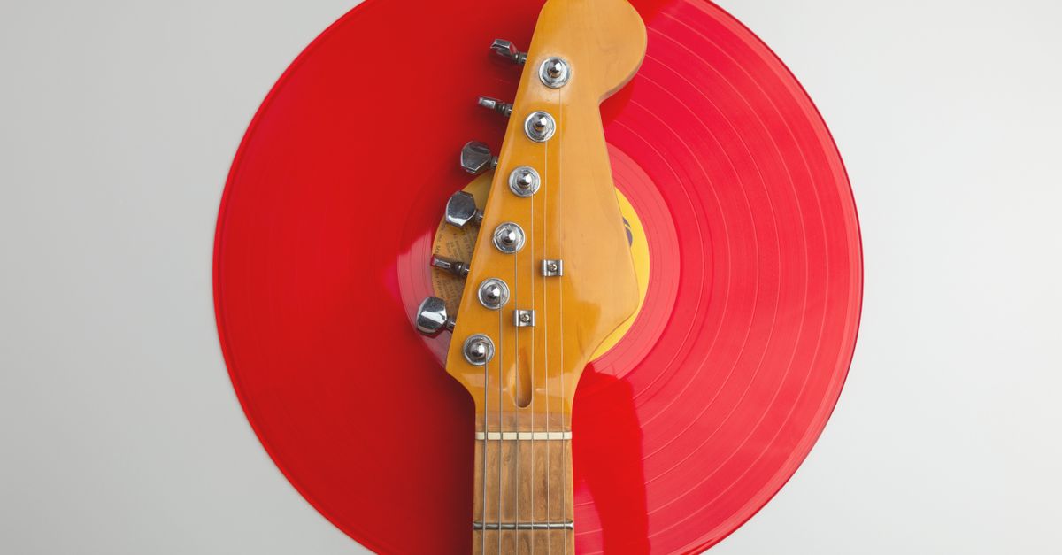 Creative close-up of an electric guitar headstock with a red vinyl record. Perfect for music-themed designs.