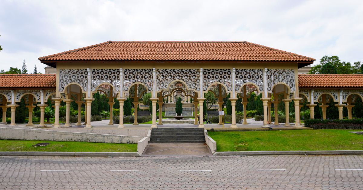 Stunning traditional pavilion featuring elegant arches and intricate latticework under a cloudy sky.