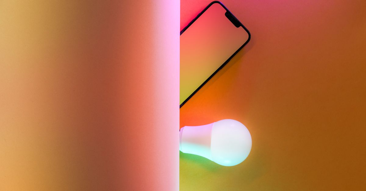 Creative abstract image featuring a smart light bulb and smartphone with colorful illumination.