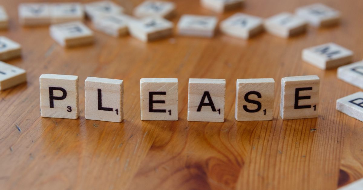 Scrabble tiles arranged to spell 'Please' on a wooden surface, symbolizing politeness.