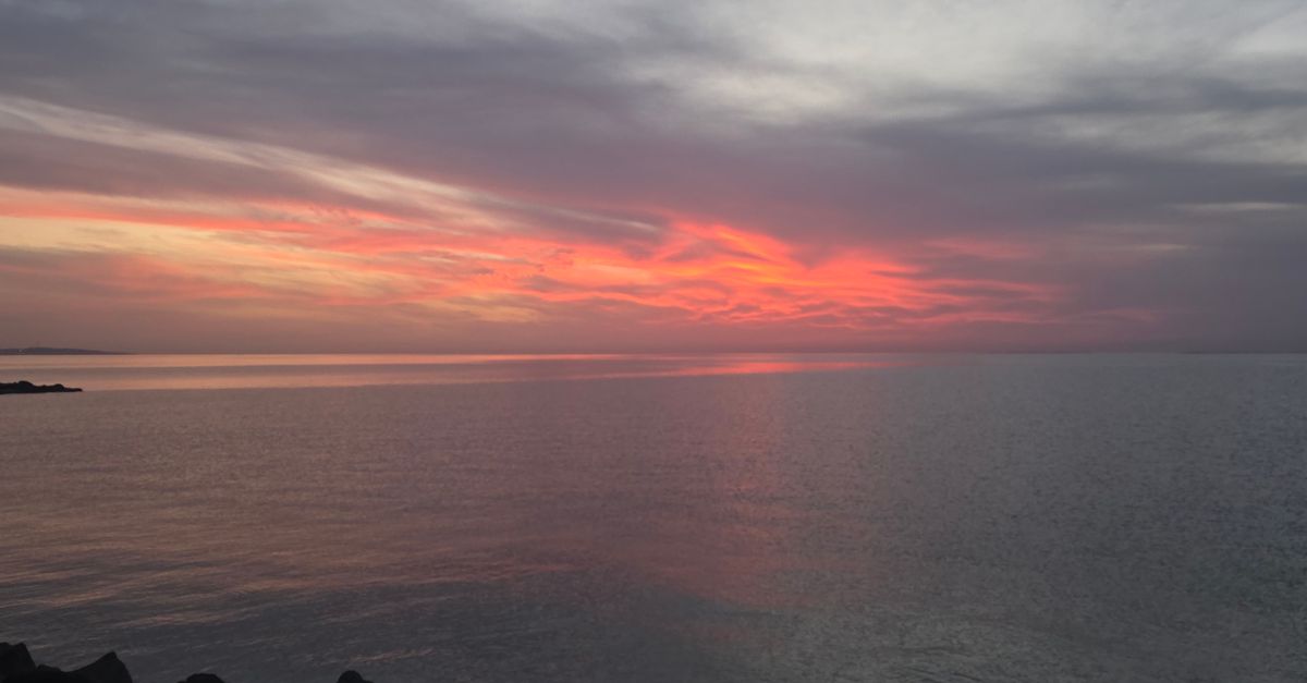 Captivating sunset over the ocean with a vivid sky and calm waters.