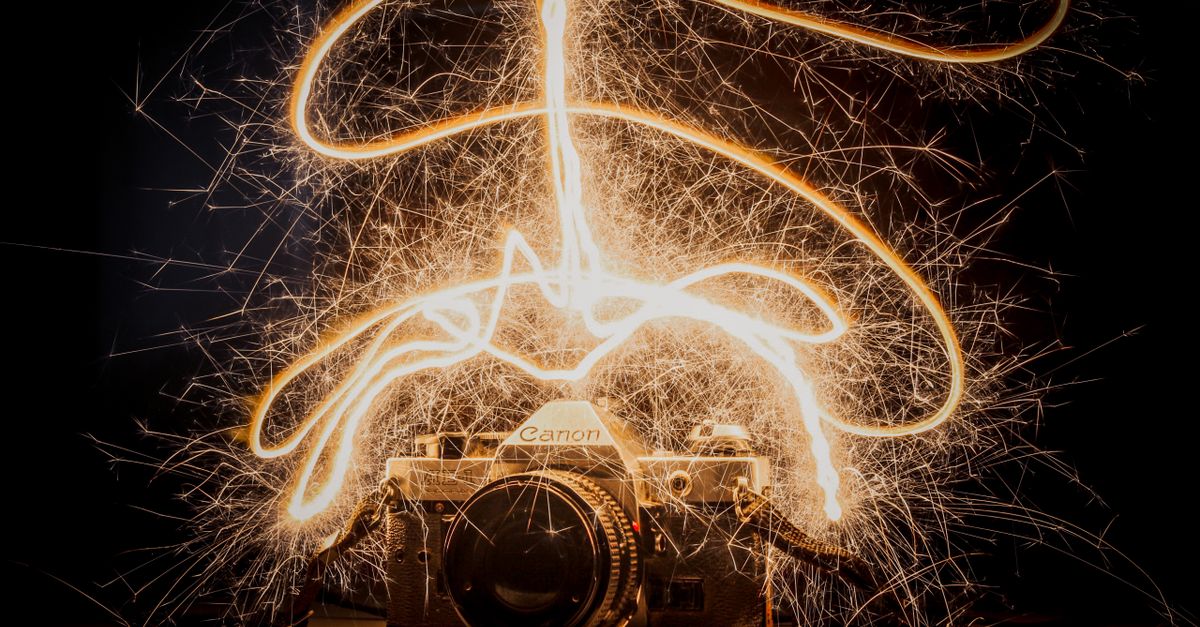 Antique camera with dynamic sparkler light trails. Captivating long exposure shot.