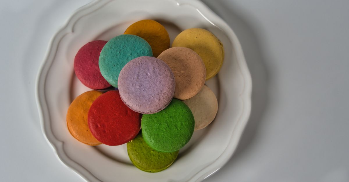 Bright and colorful French macarons arranged on a decorative plate.