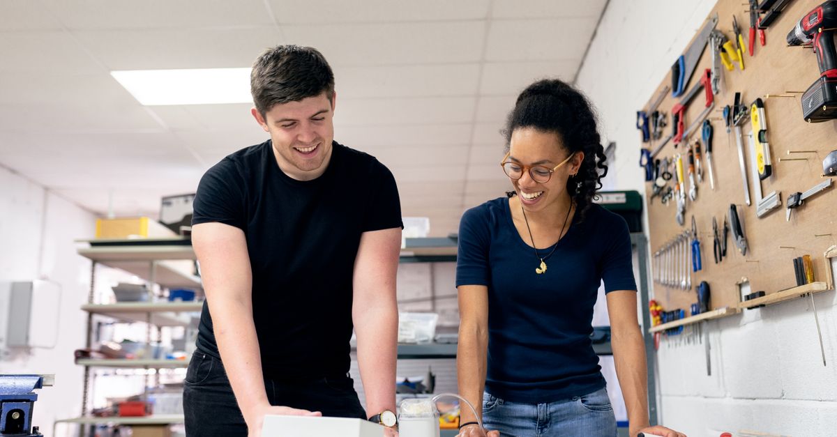 Two engineers collaborate in a workshop, engaging in hands-on prototyping and design.