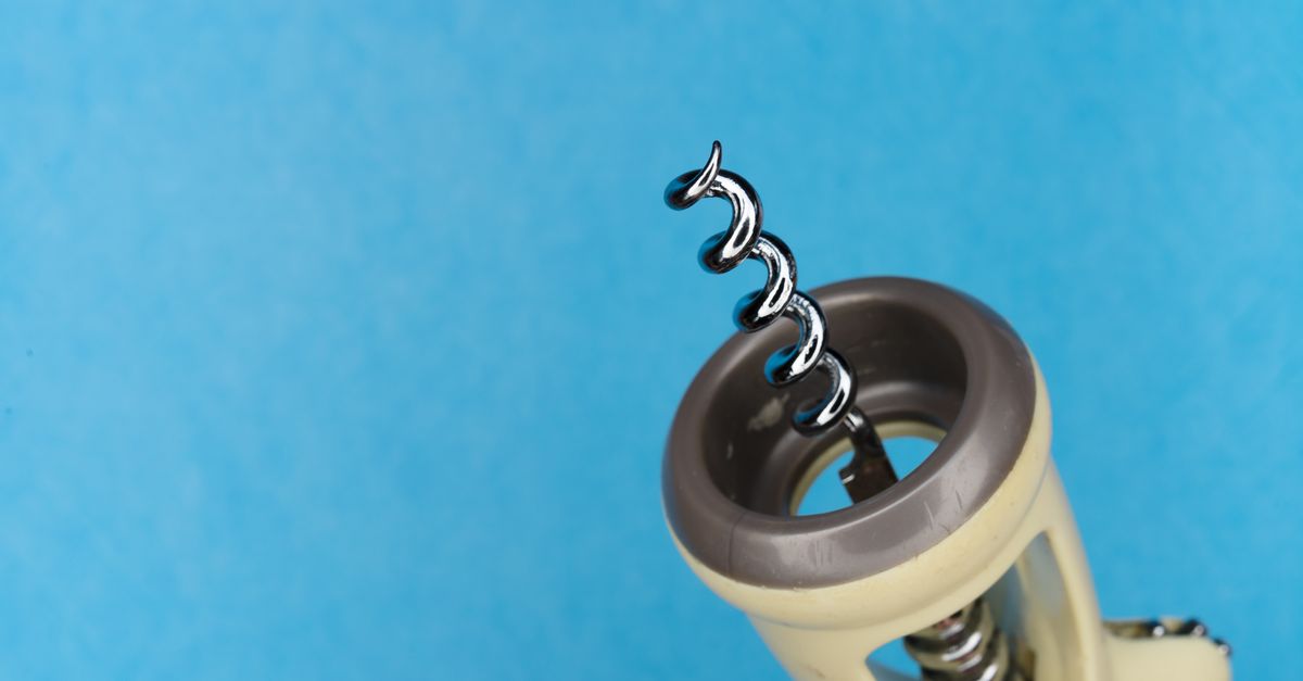 Detailed view of a corkscrew on a blue background perfect for kitchen themes.