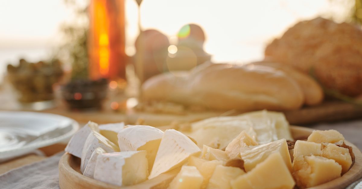 A gourmet cheese platter set against a sunny outdoor backdrop, perfect for food enthusiasts.