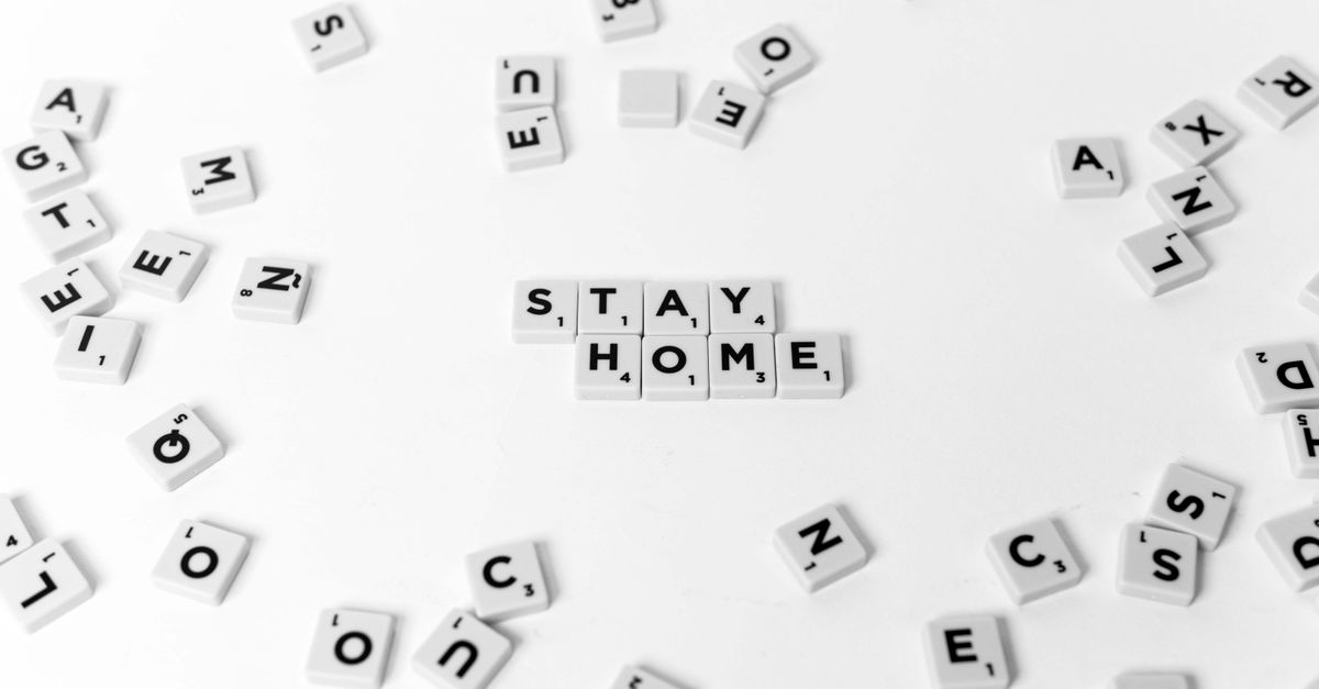 White Scrabble tiles displaying 'STAY HOME' on a pristine white background, emphasizing home isolation.