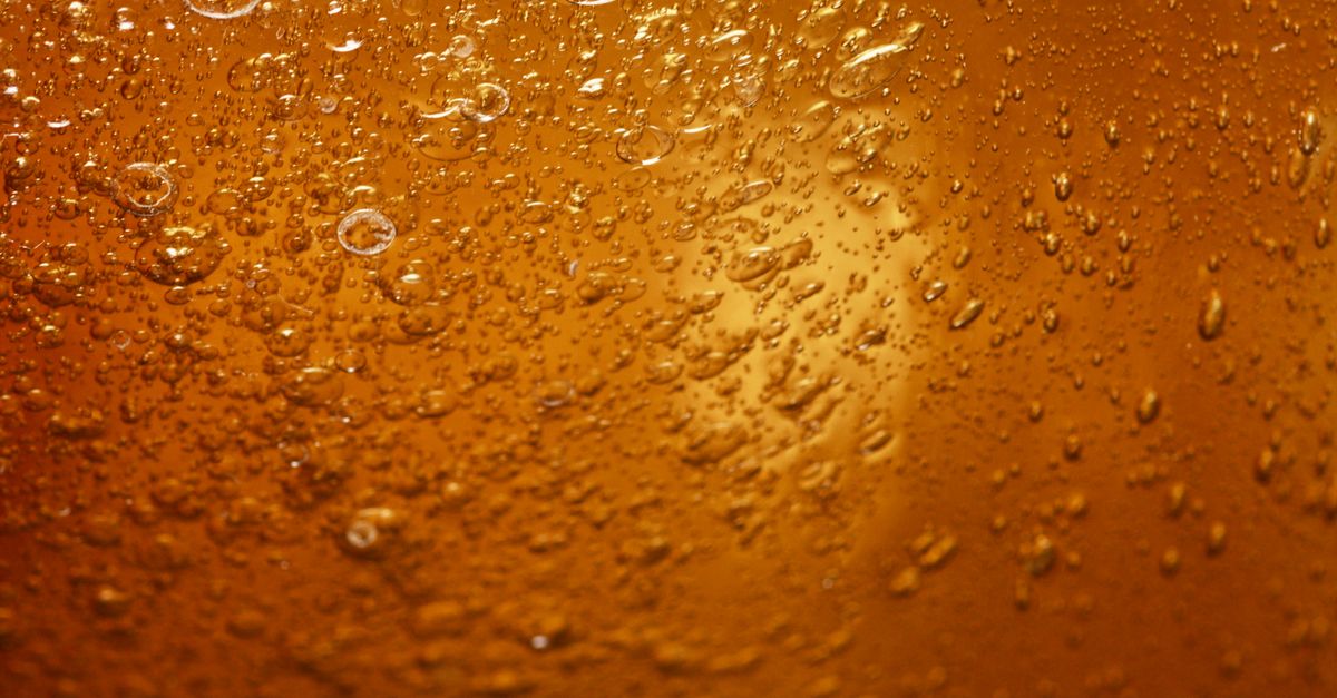 A close-up view of water droplets on an orange surface, showcasing texture and color.