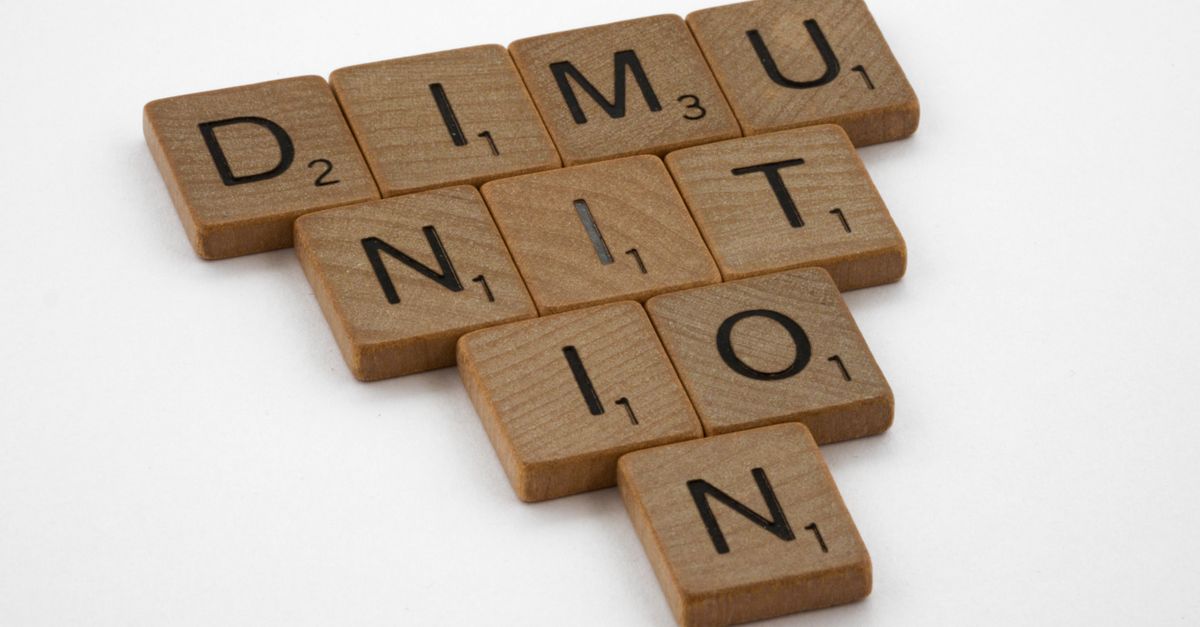 Close-up of Scrabble tiles forming the word 'diminution' in a playful layout.