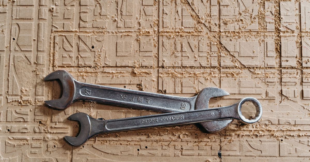 Two metal spanners placed on a textured wooden surface, showcasing industrial tools.