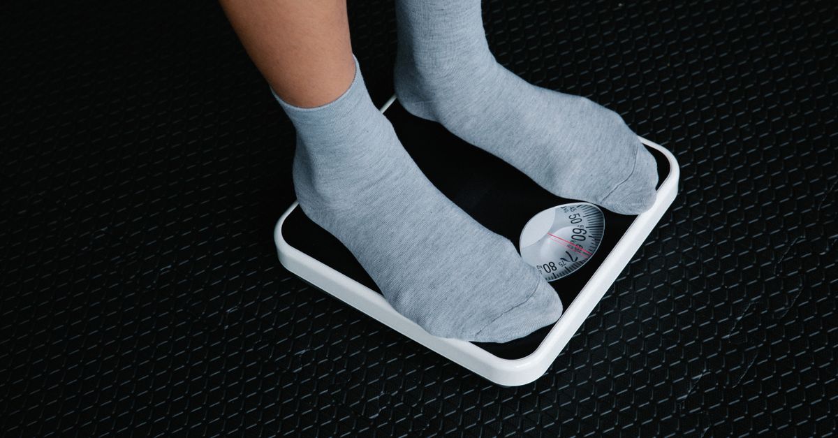 Close-up of feet in socks standing on a scale, focusing on weight measurement.