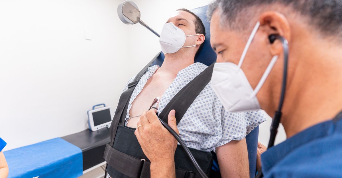 A medical practitioner conducts a chest examination on a patient using a stethoscope in a clinical setting.