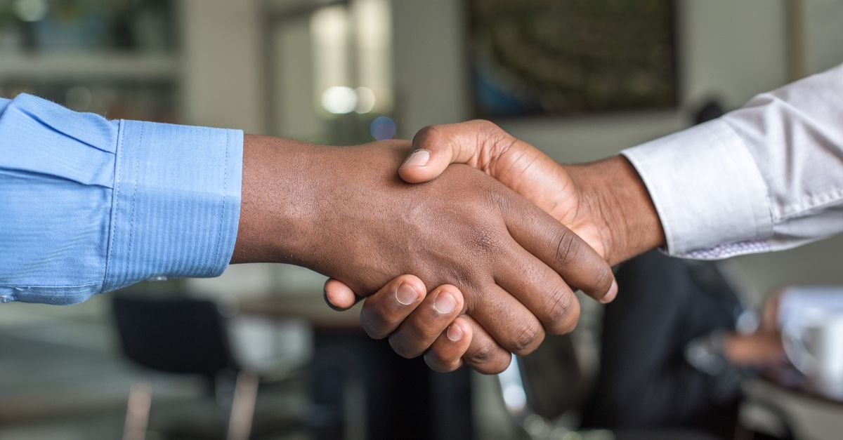 Close-up of two men's handshake symbolizing agreement in an office.