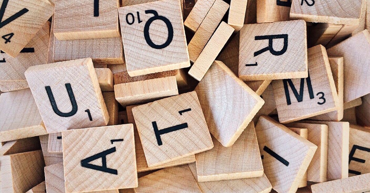 Close-up of wooden Scrabble tiles showcasing letters and numbers for word games.
