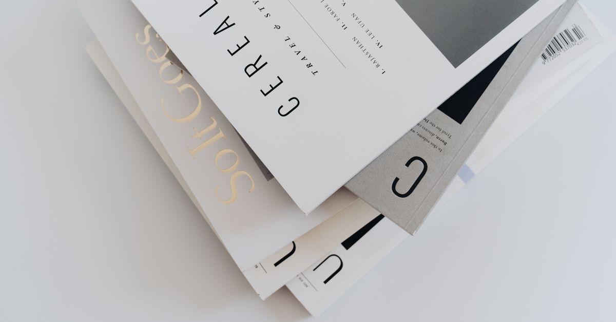 Aesthetic stack of minimalist travel and style magazines with elegant typography.