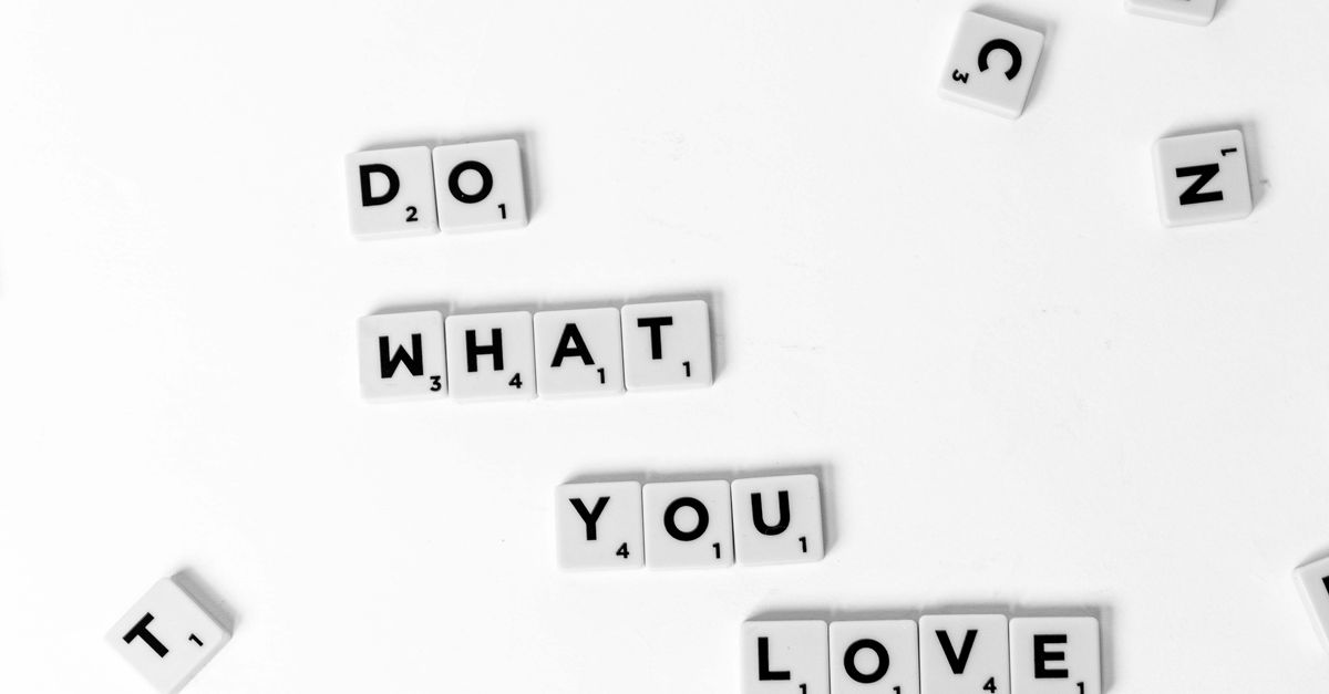 Scrabble tiles spelling 'Do What You Love' on a white background, encouraging creativity.